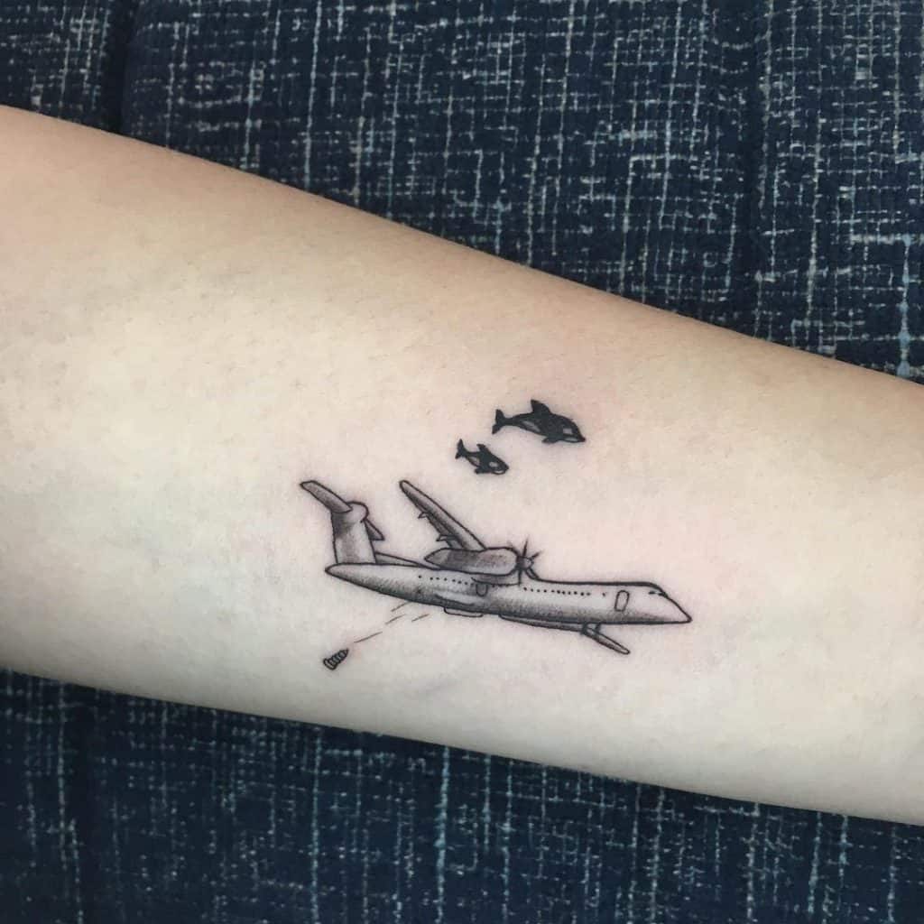 Minimalist airplane tattoo on the shoulder.
